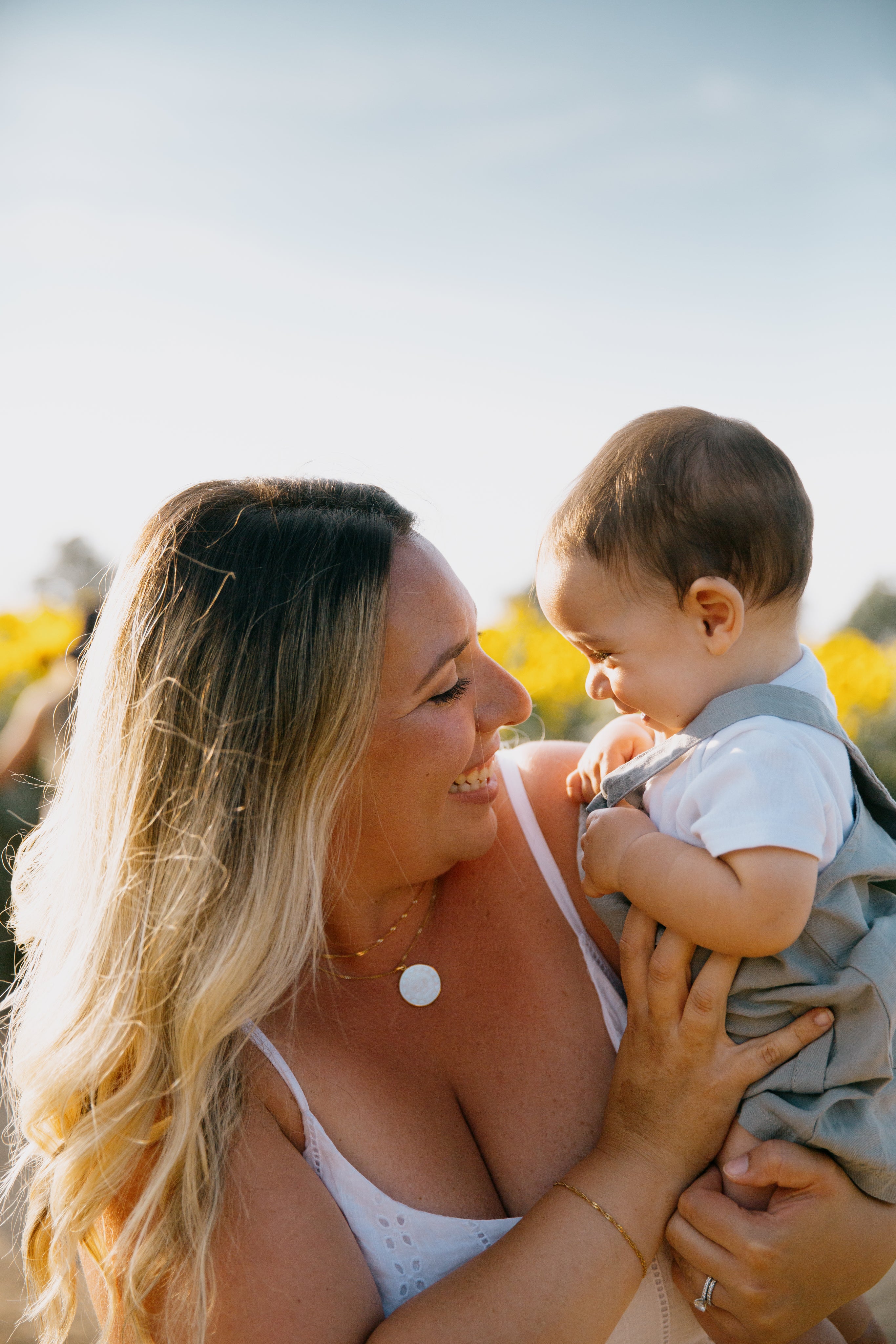 person-holds-a-baby-outside-as-they-both-giggle.jpg